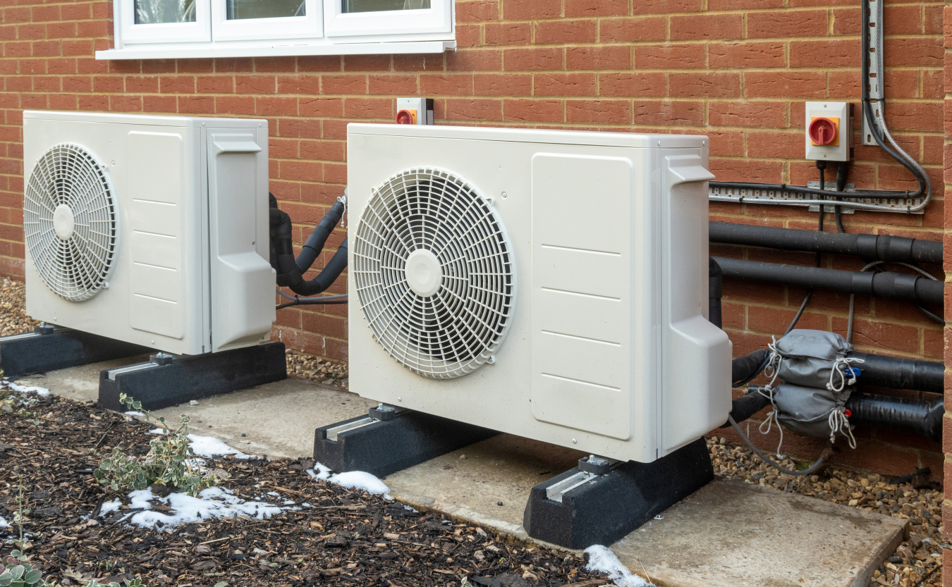 Modern heat pump unit installed outside a brick house for efficient heating