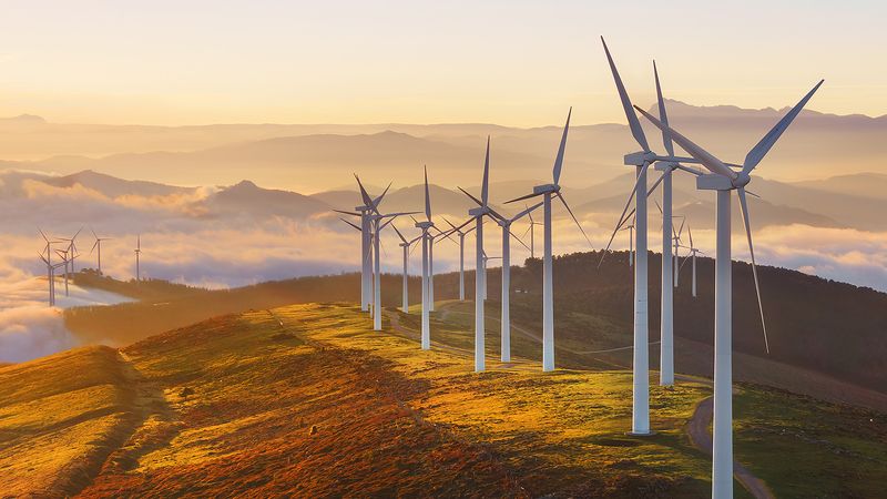 Wind turbines generating clean renewable electricity at sunset